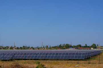 A solar power plant against the backdrop of a small residential community.