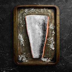 Fresh salmon fillet in a metal baking dish. Seafood. Top view. Free space for text.