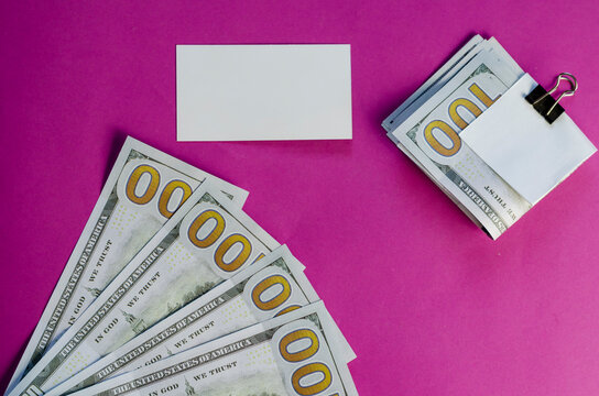 One Hundred Dollar Bills Sandwiched Binder Clip, Money And Blank Business Card On Pink Background.