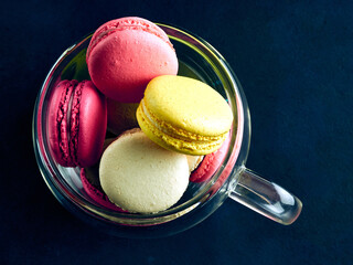 Sweet Macaron of different colors on an darke background