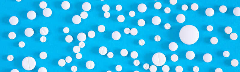 Various medicinal pills and capsules for health, dietary supplements and vitamins for heart health and antiviral agents isolated on blue background. Farm drugs.