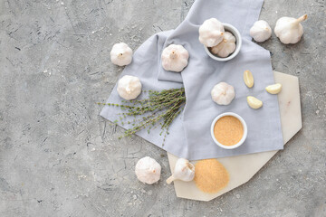 Bowl with aromatic powdered garlic on gray background