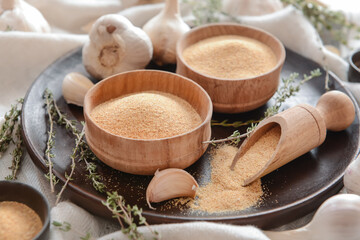 Fototapeta na wymiar Bowls with aromatic powdered garlic, closeup