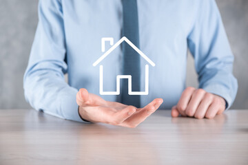 Real estate concept, businessman holding a house icon.House on Hand.Property insurance and security...