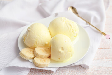 Tasty banana ice-cream on light wooden background