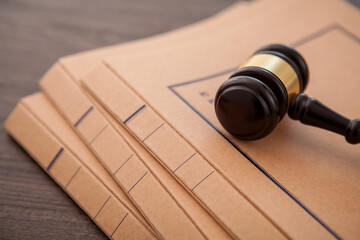 case folders with judge gavel on wooden desk.