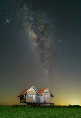Beautfiul night landscape, silhouette of a camera on the tripod at the starry night and bright milky way galaxy.