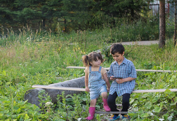 a boy and a girl play together in a smartphone in the village