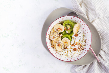 Cottage cheese with bananas, kiwi. Dietary breakfast for summertime. Top view, overhead, copy space. Eco friendly concept.