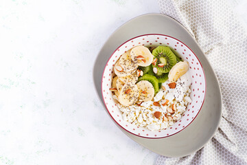 Cottage cheese with bananas, kiwi. Dietary breakfast for summertime. Top view, overhead, copy space. Eco friendly concept.