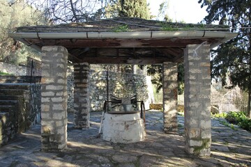 Obraz premium Old stone build well at the garden of a Greek orthodox church of 
