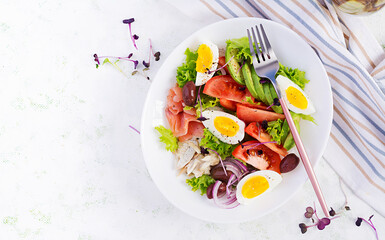 Ketogenic diet breakfast. Salt salmon and baked dorado salad with greens, tomatoes, eggs and avocado. Top view, overhead. Zero waste, eco friendly concept.