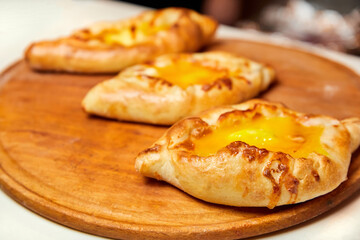 Ajarian traditional flatbread khachapuri or hachapuri with cheese, egg and butter on a plate