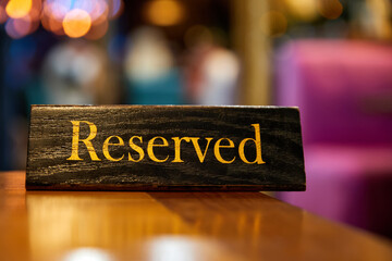 Plaque with the inscription Reserved on the restaurant table.