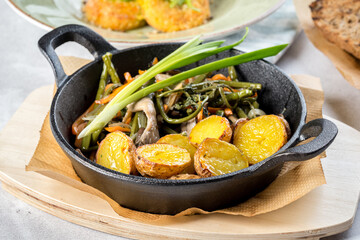 Baked potatoes in a cast iron skillet with onions