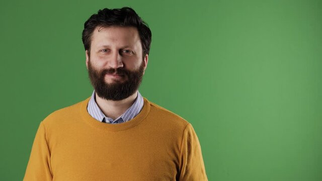 A cheerful white bearded good-looking man in a yellow sweater shows the number 96 on a white sheet. Chrome key, green screen, copy space