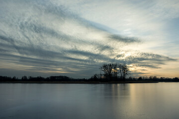 The surface of the frozen lake and clouds after sunset