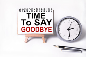 Time To Say Goodbye. text on white notepad paper on white background. near the table clock