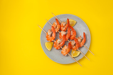 cooked shrimps on stick with lemon