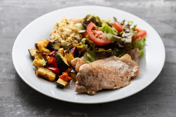 meat chops with vegetables on white plate