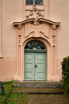 Barockes S&uuml;dportal der denkmalgesch&uuml;tzten Stadtkirche Biesenthal mit mintfarbener Holzt&uuml;r