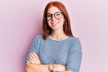 Young red head girl wearing casual clothes and glasses happy face smiling with crossed arms looking...