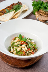 Bean salad in a white plate filmed for the menu
