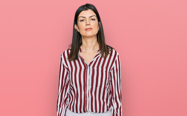 Fototapeta premium Beautiful brunette woman wearing striped shirt relaxed with serious expression on face. simple and natural looking at the camera.