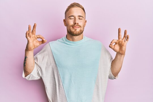 Young caucasian man wearing casual clothes relax and smiling with eyes closed doing meditation gesture with fingers. yoga concept.