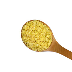 Millet flakes in a wooden spoon isolated on white bacground.