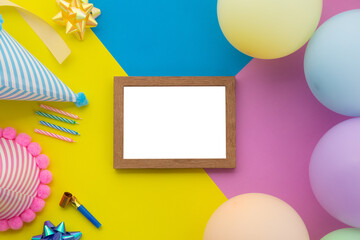 Happy birthday background, Flat lay colorful party decoration with flyer invitation card on pastel yellow, blue and pink geometric background.