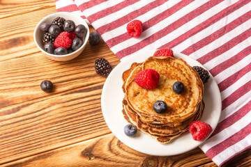 Pancakes And Berries On Wooden Background