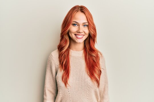 Young beautiful redhead woman wearing casual winter sweater with a happy and cool smile on face. lucky person.