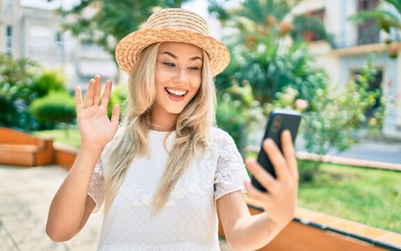 Young caucasian tourist girl doing video call using smartphone at city.