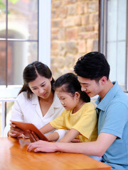 Happy family of three using tablet