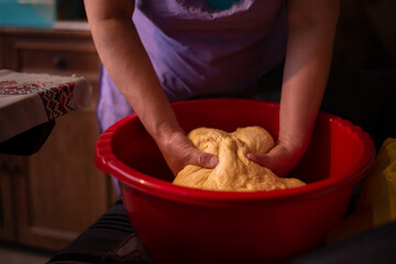 housewife kneading the dough by hand. preparation of the recipe for traditional Romanian homemade cakes known as cozonac