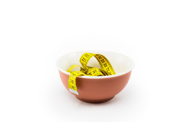 yellow measuring tape inside a bowl of diet food on white background