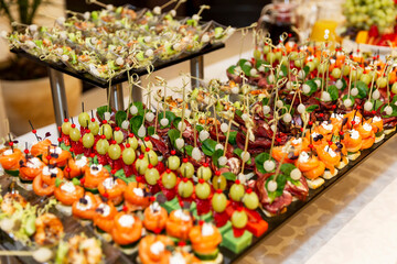 Rows of mouth-watering canapes on the festive table. Catering for business meetings, events and celebrations.