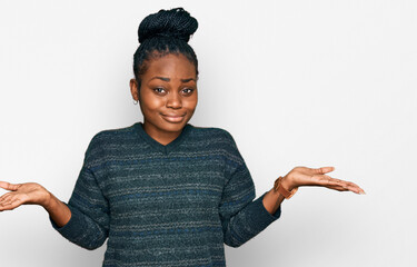 Young african american woman wearing casual clothes clueless and confused expression with arms and...