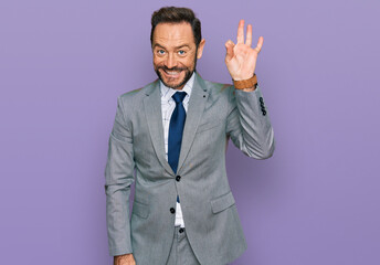 Middle age man wearing business clothes smiling positive doing ok sign with hand and fingers. successful expression.