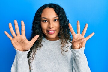Young latin woman wearing casual clothes showing and pointing up with fingers number nine while...