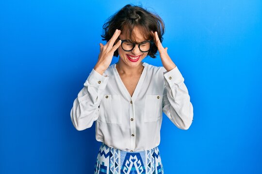 Young brunette woman wearing casual clothes and glasses with hand on head for pain in head because stress. suffering migraine.