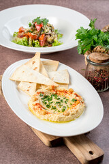 Hummus with tortilla on a white plate