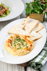 Hummus with tortilla on a white plate