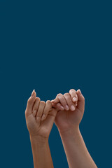 Close up of two hands hooking each other little finger pinkie as a symbol of promise or pardon...