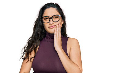 Brunette young woman wearing casual clothes and glasses touching mouth with hand with painful expression because of toothache or dental illness on teeth. dentist