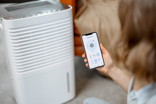 Smartphone with launch application for air purifier appliance, air quality monitoring. Health microclimate at home concept. 