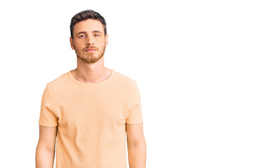 Fototapeta premium Handsome young man with bear wearing casual yellow tshirt relaxed with serious expression on face. simple and natural looking at the camera.