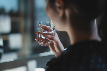 水を飲むパジャマの女性