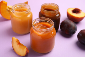 Healthy baby food and ingredients on violet background